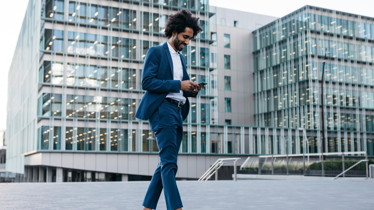 Man walking past offices on his phone